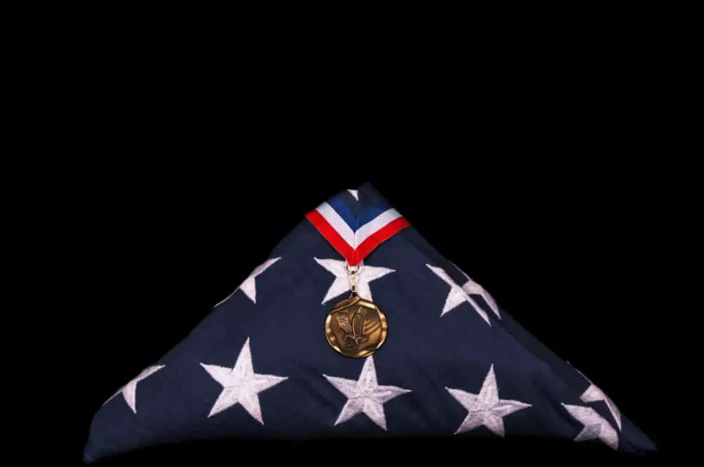 Folded US flag from veteran s casket and medal