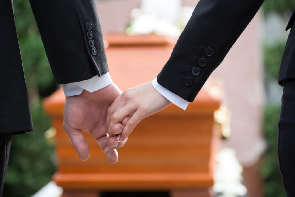 couple at funeral holding hands consoling each other